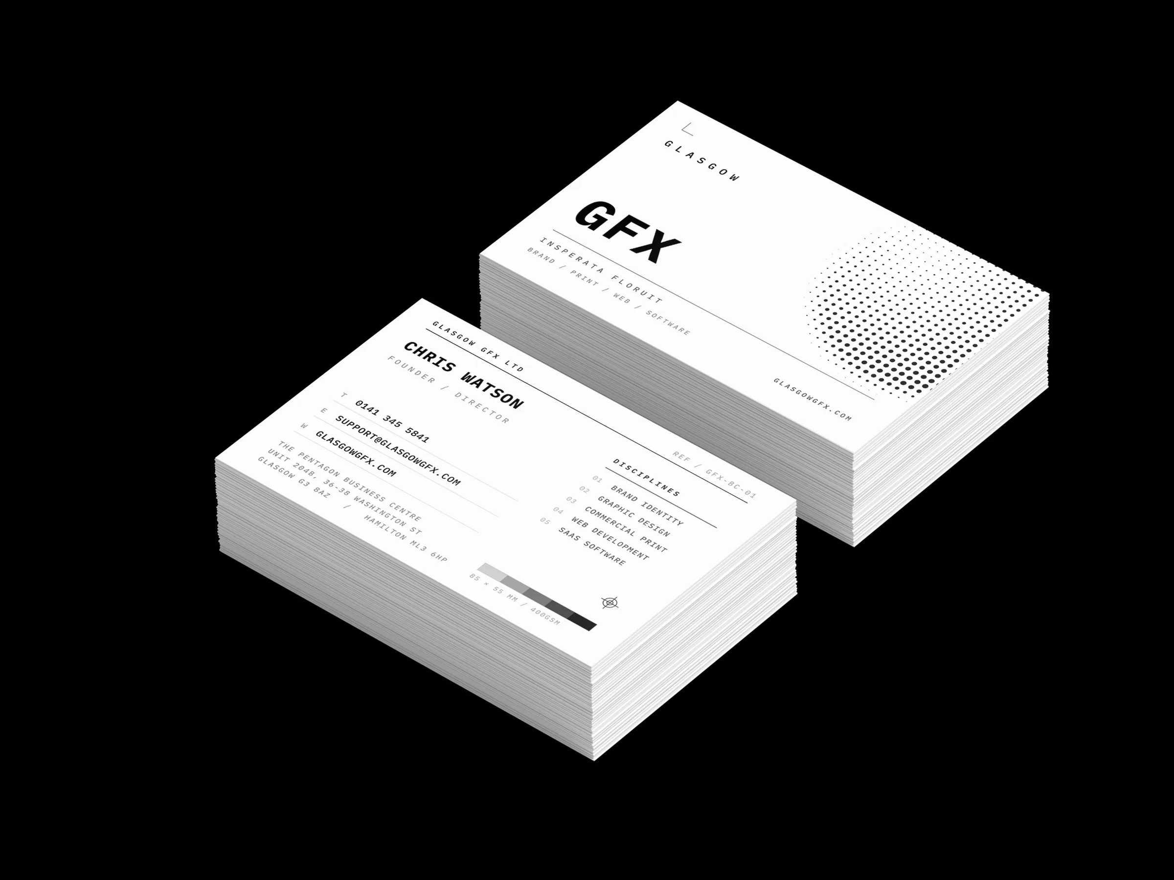 Double-sided 85x55mm business cards printed on black stock, front and back, in two stacks on a white studio surface