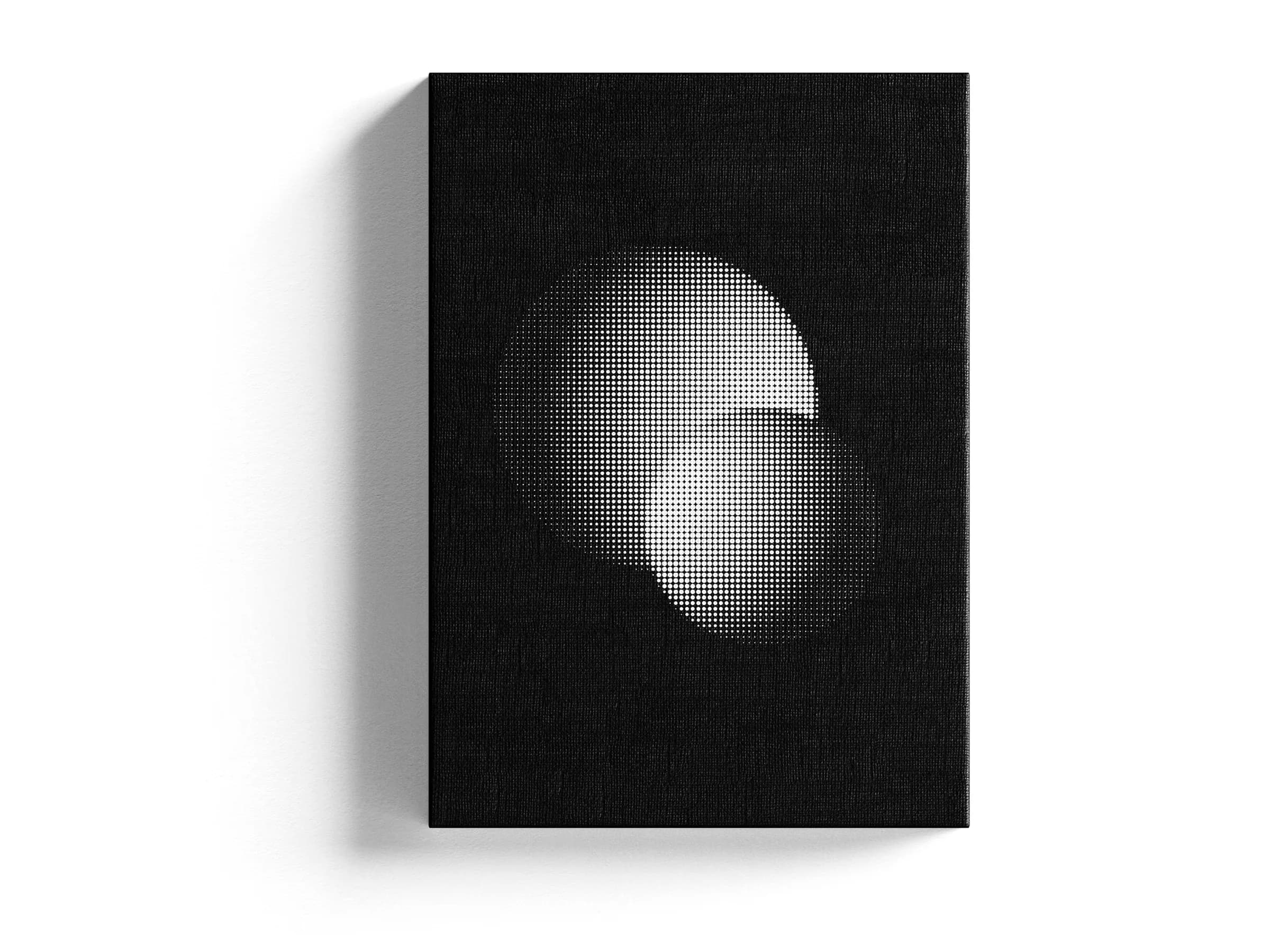 Stretched canvas print of a halftone eclipse artwork on a white studio surface