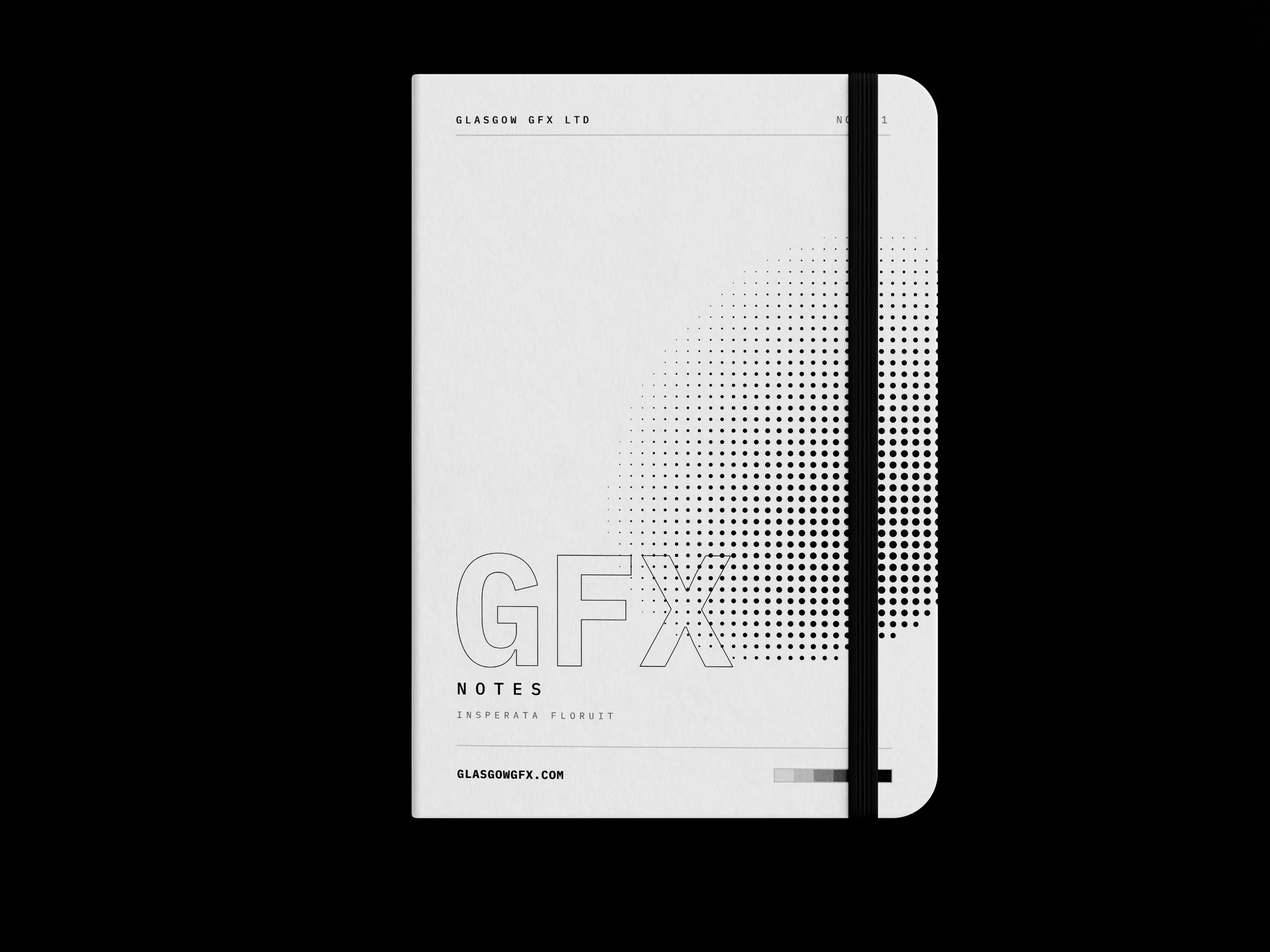 A5 notebook with printed cover and elastic band on a white studio surface