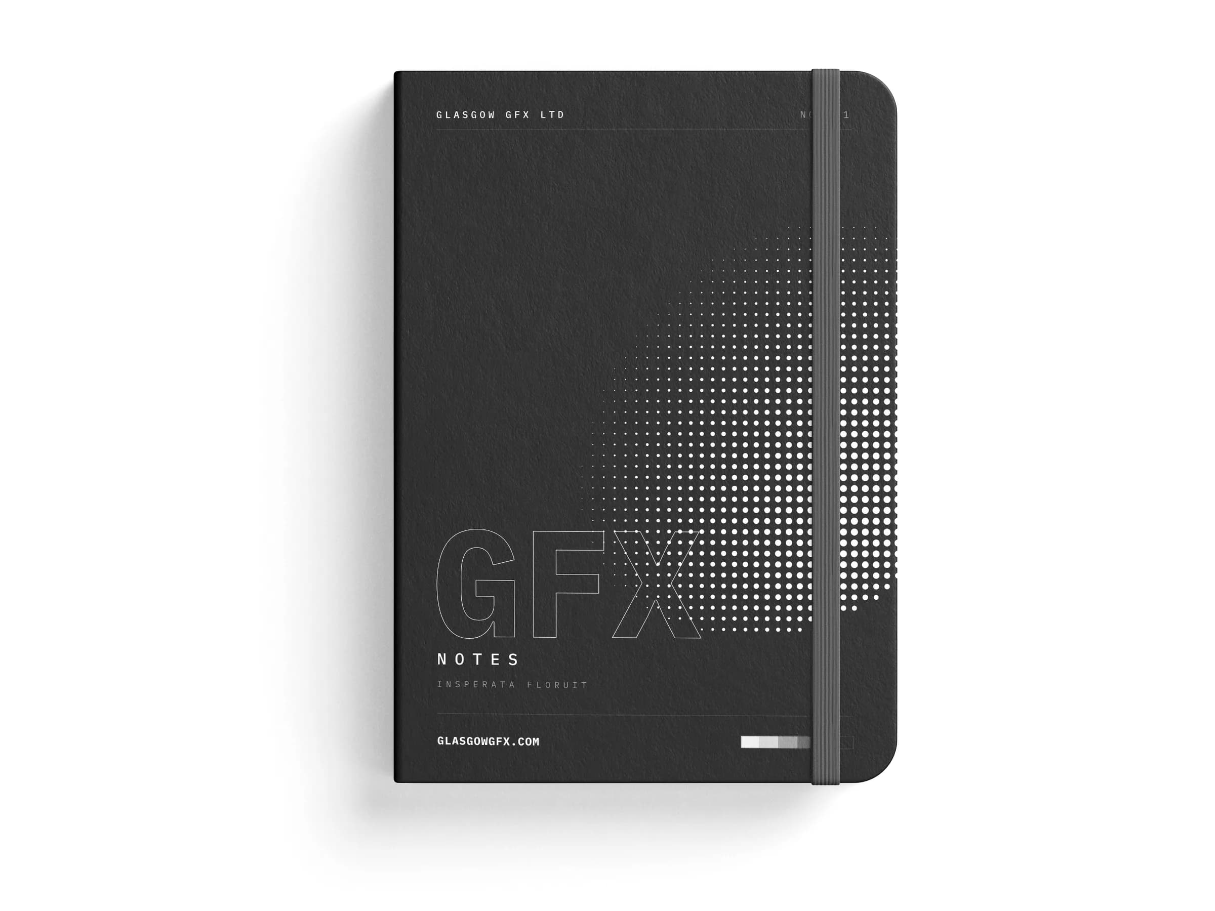 A5 notebook with printed cover and elastic band on a white studio surface