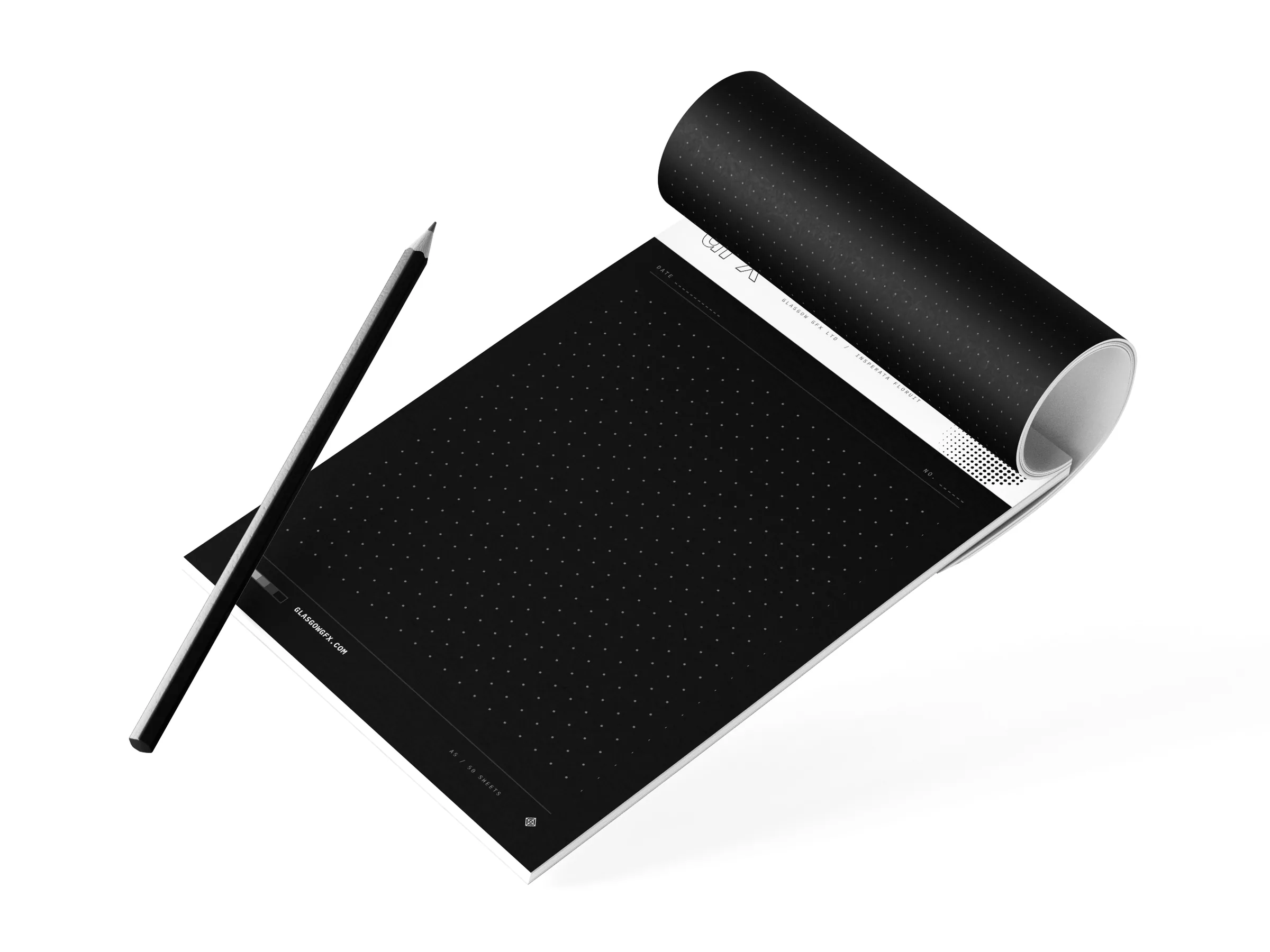 A5 dot-grid notepad with a printed header band, top sheet rolled back, beside a pencil on a white studio surface